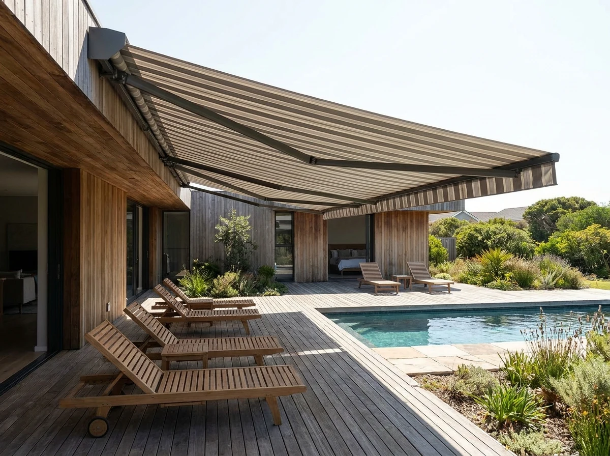A folding-arm awning extended over a poolside deck